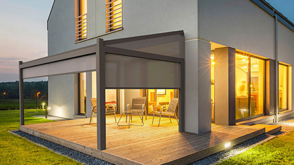 Terrassenüberdachung mit Seitenelement an einem modernen Wohnhaus