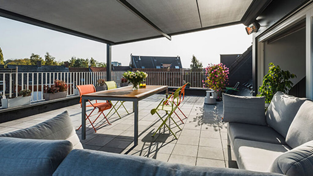 Überdachte Dachterrasse mit Sitzgruppe und Nachbarhäusern