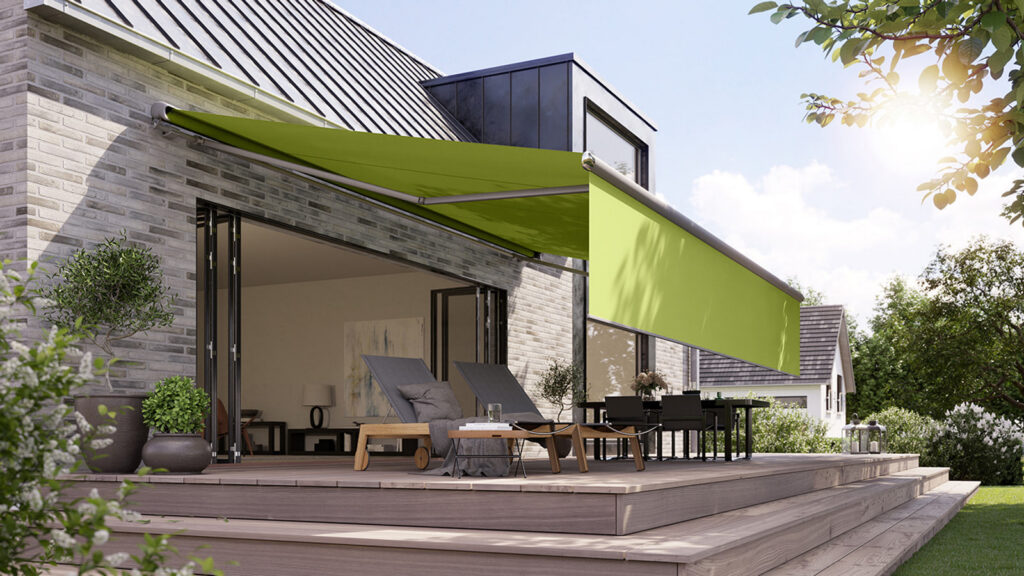 Grüne Markise an einem hellen Klinker-Wohnhaus mit Terrasse
